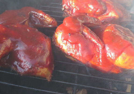 Smoky barbecue chicken cooking on grill